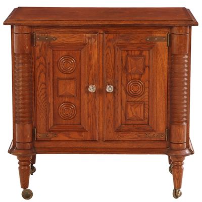TWO DOOR FRENCH OAK BAR CABINET C 1940 HAVING CIRCULAR MOTIFS,  TURNED LEGS AND BALL FEET IN THE