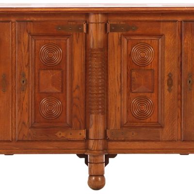 FRENCH OAK FOUR DOOR SIDEBOARD C 1940 HAVING CIRCULAR MOTIFS,  TURNED LEGS AND BALL FEET IN THE