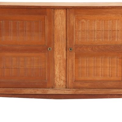A FRENCH OAK SERVER HAVING TWO DOORS IN THE MANNER OF RENE GABRIEL C 1940.
