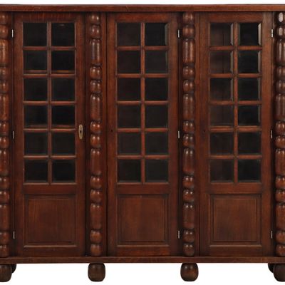 THREE DOOR OAK CABINET HAVING TURNED COLUMNS AND BEVELED GLASS PANELS C 1940. DISMANTLES FOR