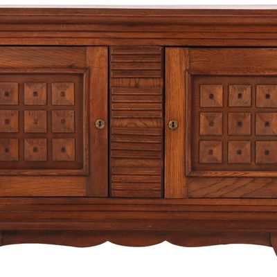 ONE OF TWO FRENCH OAK TWO DOOR SERVERS WITH GEOMETRIC MOTIFS IN THE MANNER OF DUDOUYT C 1940.