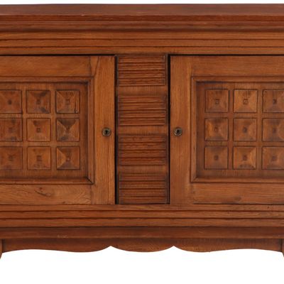 ONE OF TWO FRENCH OAK TWO DOOR SERVERS WITH GEOMETRIC MOTIFS IN THE MANNER OF DUDOUYT C 1940.