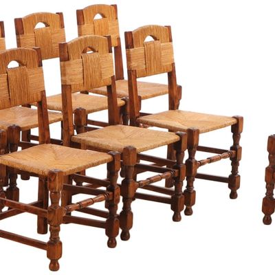 EIGHT FRENCH OAK AND RUSH DINING CHAIRS HAVING A WRAPPED EFFECT IN THE MANNER OF CHARLES DUDOUYT C