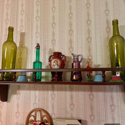 Sale Photo Thumbnail #40: Collection of vintage glassware and decorative items, including green glass bottles, a portrait vase, and a small iridescent pitcher.