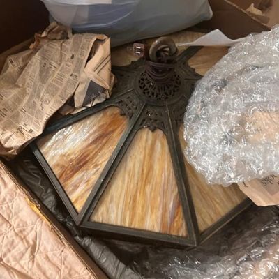 Sale Photo Thumbnail #36: Vintage slag glass hanging light fixture featuring a metal frame with ornate detailing and warm amber-toned glass panels.