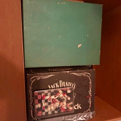Sale Photo Thumbnail #69: Vintage Jack Daniel's branded box alongside a green storage box and a miniature travel chess set.