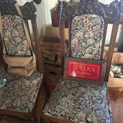 Sale Photo Thumbnail #123: Pair of antique carved oak dining chairs with floral tapestry upholstery, accompanied by a vintage wooden Bulova Clocks sign.