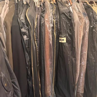 Sale Photo Thumbnail #72: Assorted men's suits, jackets, and outerwear, some protected in garment bags.