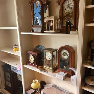 Sale Photo Thumbnail #24: Collection of antique mantel and shelf clocks, featuring ornate wooden cases and brass-framed pendulum designs.