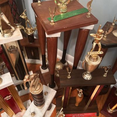 Sale Photo Thumbnail #125: Collection of vintage sports trophies, primarily featuring baseball and softball themes with wooden and marble bases.