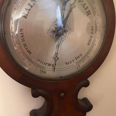 Sale Photo Thumbnail #113: Vintage aneroid barometer with a wooden frame and decorative hands.