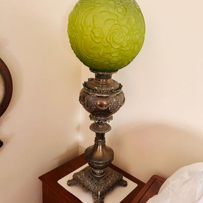 Sale Photo Thumbnail #10: Victorian-style banquet lamp featuring an ornate cast metal base and a green satin glass globe with embossed floral details.