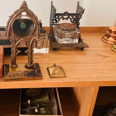Sale Photo Thumbnail #14: Collection of antique brass and cast iron desk accessories, including inkwells and decorative stands.