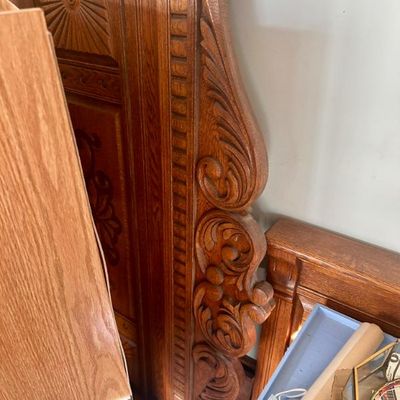 Sale Photo Thumbnail #56: Antique carved oak headboard featuring ornate scrollwork and a sunburst medallion.