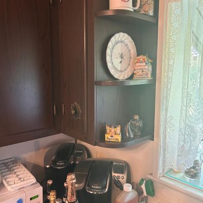 Sale Photo Thumbnail #42: Keurig coffee makers, a microwave, and various kitchen collectibles including a vintage Pepsi-Cola mini bottle set and decorative plates.