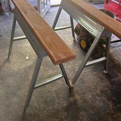 Sale Photo Thumbnail #118: Pair of metal sawhorses with wooden top planks.