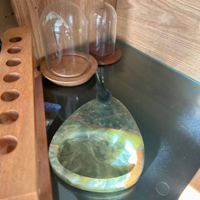 Sale Photo Thumbnail #13: Vintage green onyx desk set with a pen holder and integrated tray, alongside two small glass display domes with wooden bases.