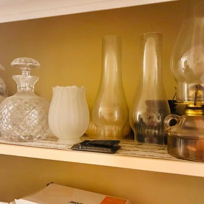 Sale Photo Thumbnail #25: Collection of vintage glassware, including cut-glass decanters, a frosted glass vase, replacement oil lamp chimneys, and a complete glass oil lamp.