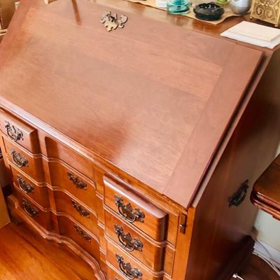 Sale Photo Thumbnail #59: Vintage cherry wood slant-front secretary desk featuring a serpentine drawer front and ornate brass batwing pulls.
