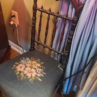 Sale Photo Thumbnail #48: Antique Victorian-style side chair featuring an ornately carved wooden frame with spindle back details and a needlepoint floral seat cushion.