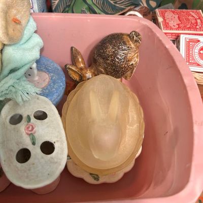 Sale Photo Thumbnail #82: Assorted vintage rabbit figurines, including a frosted glass rabbit on a nest and a brown ceramic rabbit.