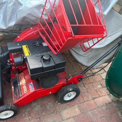 Sale Photo Thumbnail #7: Troy-Bilt Chipper Vac with a red metal frame and black engine components.