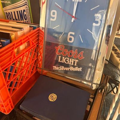 Sale Photo Thumbnail #102: Vintage Coors Light "The Silver Bullet" electric wall clock featuring a blue face and chrome-style frame.
