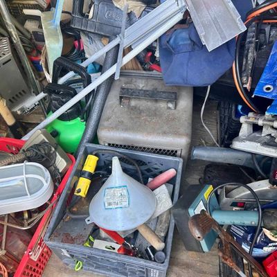Sale Photo Thumbnail #97: Assorted garage tools and equipment, including a vintage metal heater, a plastic funnel, hand tools, and a utility light.