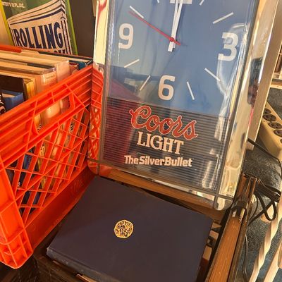 Sale Photo Thumbnail #127: Vintage Coors Light "The Silver Bullet" electric wall clock with a mirrored frame and blue face.