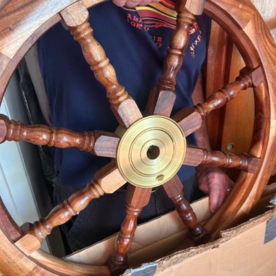 Sale Photo Thumbnail #16: Vintage wooden ship's wheel featuring a polished brass center hub and turned spokes.