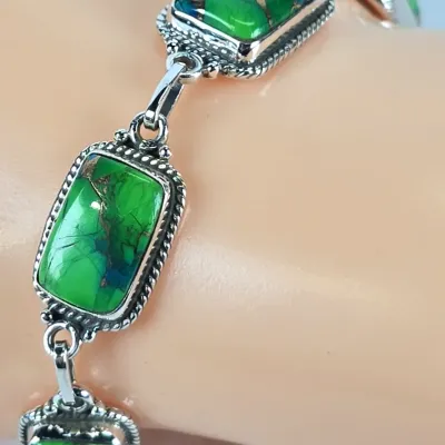 Sterling silver link bracelet featuring rectangular green turquoise cabochons with copper matrix, set in rope-textured bezels.