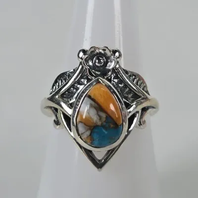 Sterling silver ring featuring a teardrop-shaped spiny oyster and turquoise composite stone, accented with a floral and leaf motif.