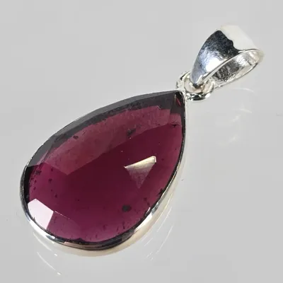 Teardrop-shaped faceted purple gemstone pendant set in a sterling silver bezel with a polished bail.