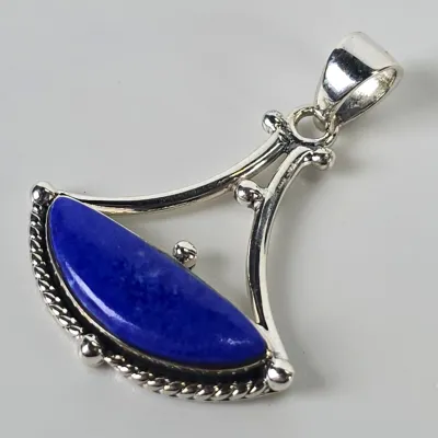 Sterling silver pendant featuring a vibrant, crescent-shaped lapis lazuli cabochon set in a decorative, openwork frame.