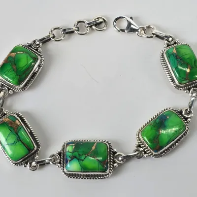 Sterling silver link bracelet featuring five rectangular green turquoise stones with copper matrix, secured with a lobster claw clasp.
