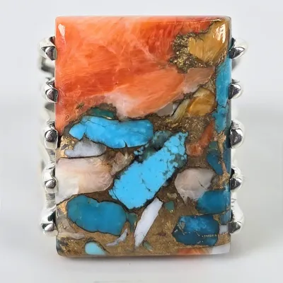 Southwestern-style sterling silver ring featuring a large rectangular composite stone of spiny oyster shell, turquoise, and bronze matrix.