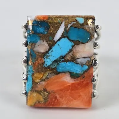Southwestern-style sterling silver ring featuring a large rectangular composite stone of turquoise, spiny oyster shell, and bronze matrix.