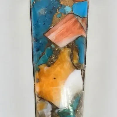 Elongated trapezoidal pendant featuring a colorful mosaic inlay of turquoise, spiny oyster shell, and other stones with metallic matrix...