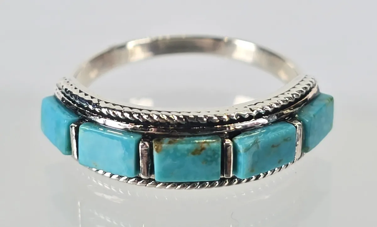 Sterling silver band ring featuring five rectangular turquoise inlay stones bordered by a twisted rope pattern, in a Southwestern style.