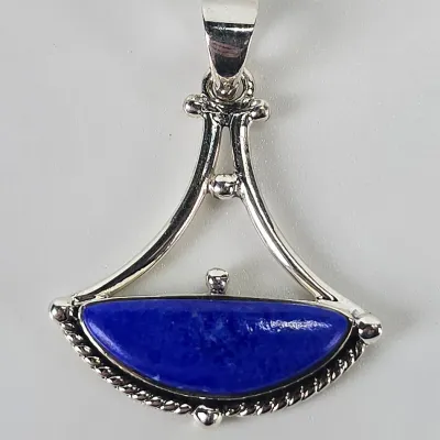 Sterling silver pendant featuring a semi-circular lapis lazuli cabochon in a rope-textured bezel, suspended from an openwork triangular...
