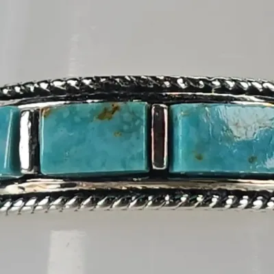 Native American style sterling silver ring featuring a channel-inlay design with rectangular turquoise stones and twisted rope wire borders.