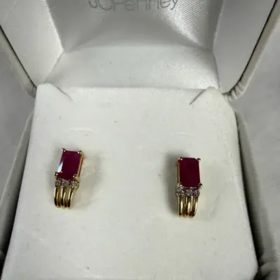 14k yellow gold, accented by a row of small clear diamonds directly beneath the prong-set ruby cente