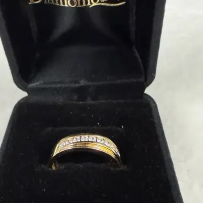 14k yellow gold channel-set multi-stone band ring featuring a single horizontal row of round-cut gem