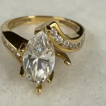 14k yellow gold engagement ring featuring a large, eye-catching marquise cut center gemstone