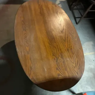 Vintage oval oak coffee table featuring a prominent wood grain pattern and a warm brown finish.