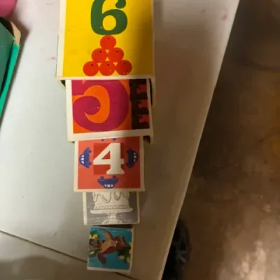 Vintage nesting blocks featuring colorful numbers and illustrations, showing some wear from age and use.