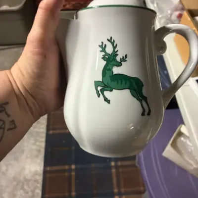 Gmundner Keramik green stag pattern ceramic coffee or teapot with lid, featuring a hand-painted green deer motif on white glaze.
