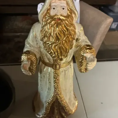 Vintage ceramic Father Christmas figurine, featuring a hooded white robe with gold-painted trim, beard, and belt details.