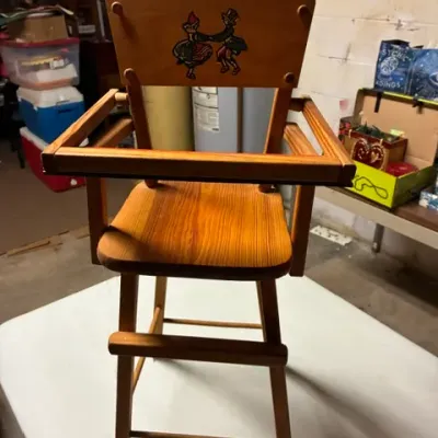 Vintage wooden doll high chair featuring a hand-painted illustration of a dancing couple on the backrest.