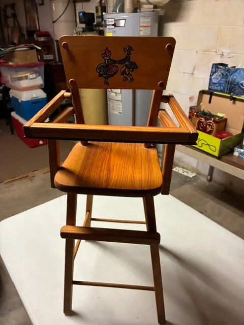 Vintage wooden doll high chair featuring a hand-painted illustration of a dancing couple on the backrest.
